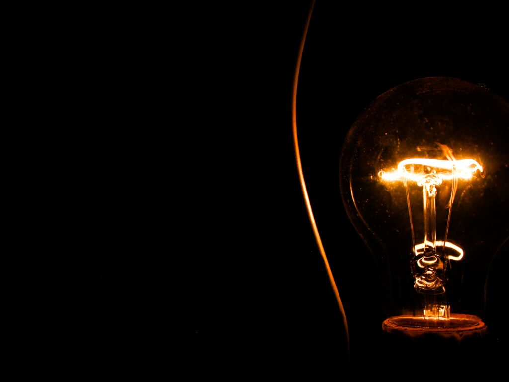 Dimmed lightbulb casting a soft glow in a dark room